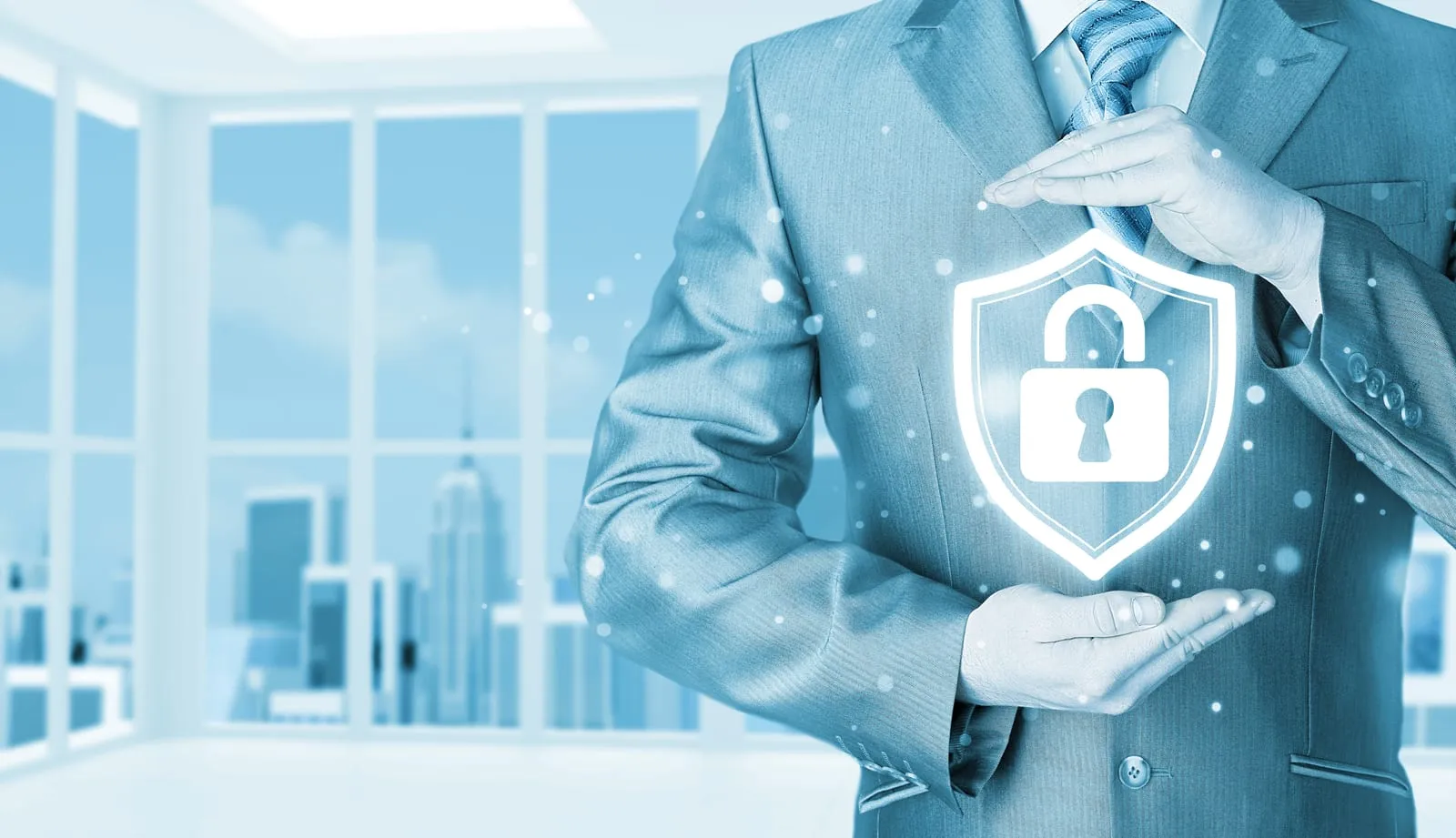 Businessman holding the glowing shield of a digital padlock in a light blue office