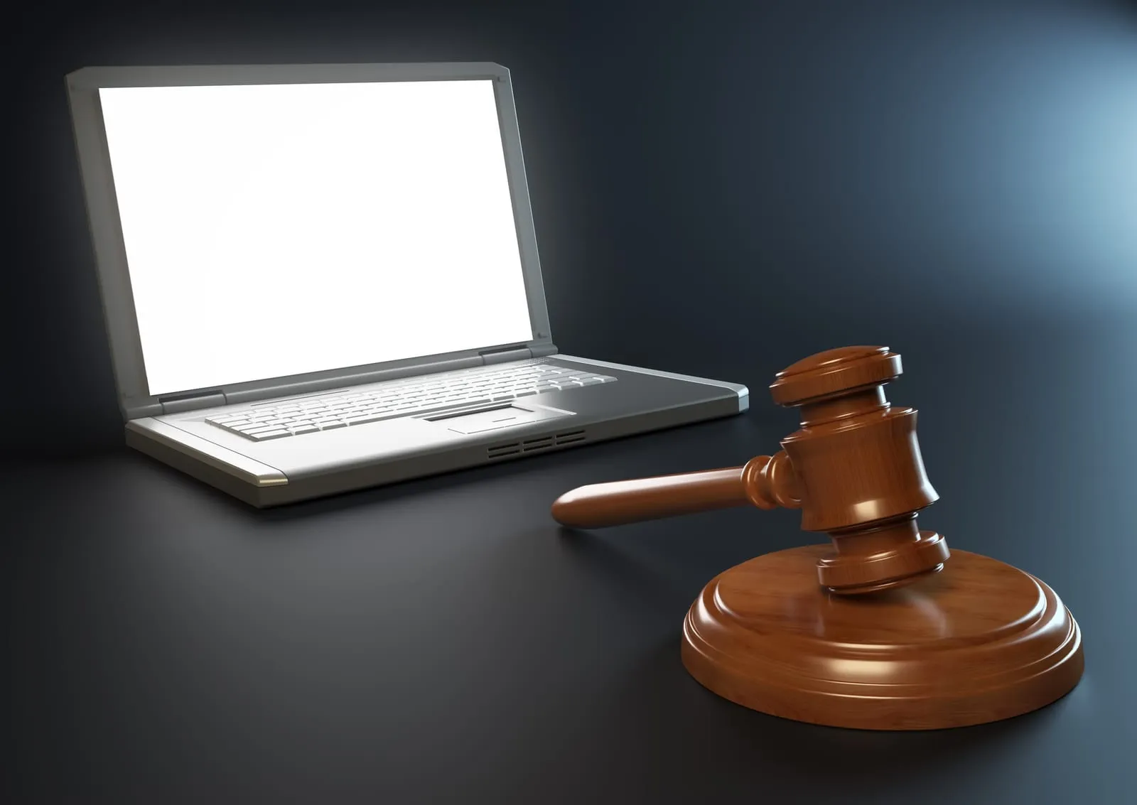 Judge’s gavel resting next to an open laptop